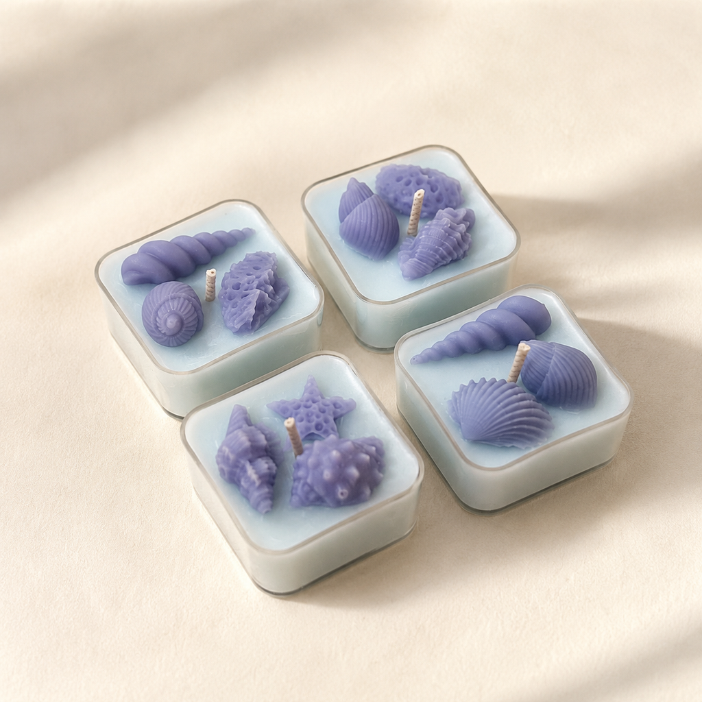 Set of four handmade shell tea lights in soft blue wax with ocean-inspired details, scented in Amalfi Bleu
