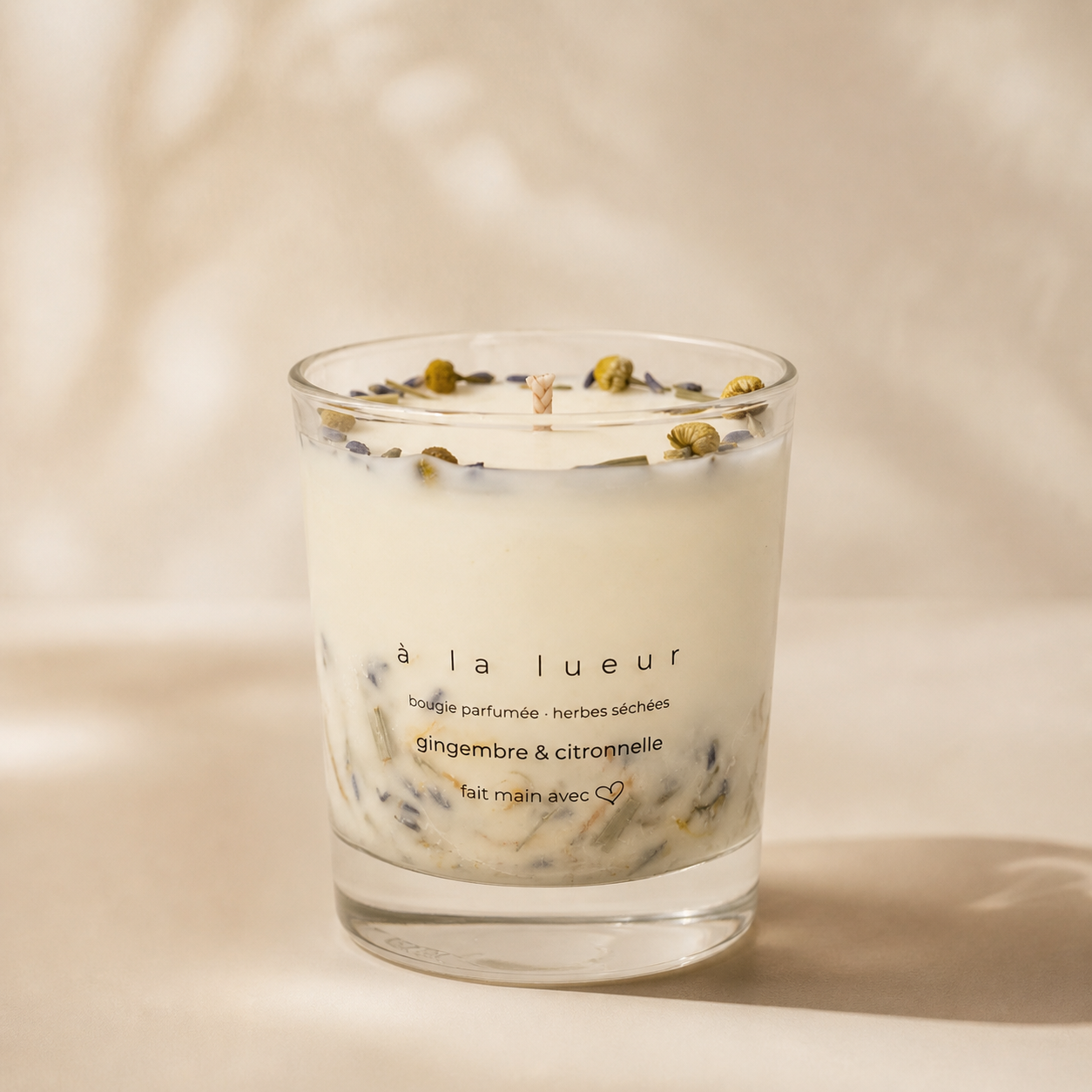 Handmade soy candle with dried herbs in a clear glass vessel from the Everyday Glow collection