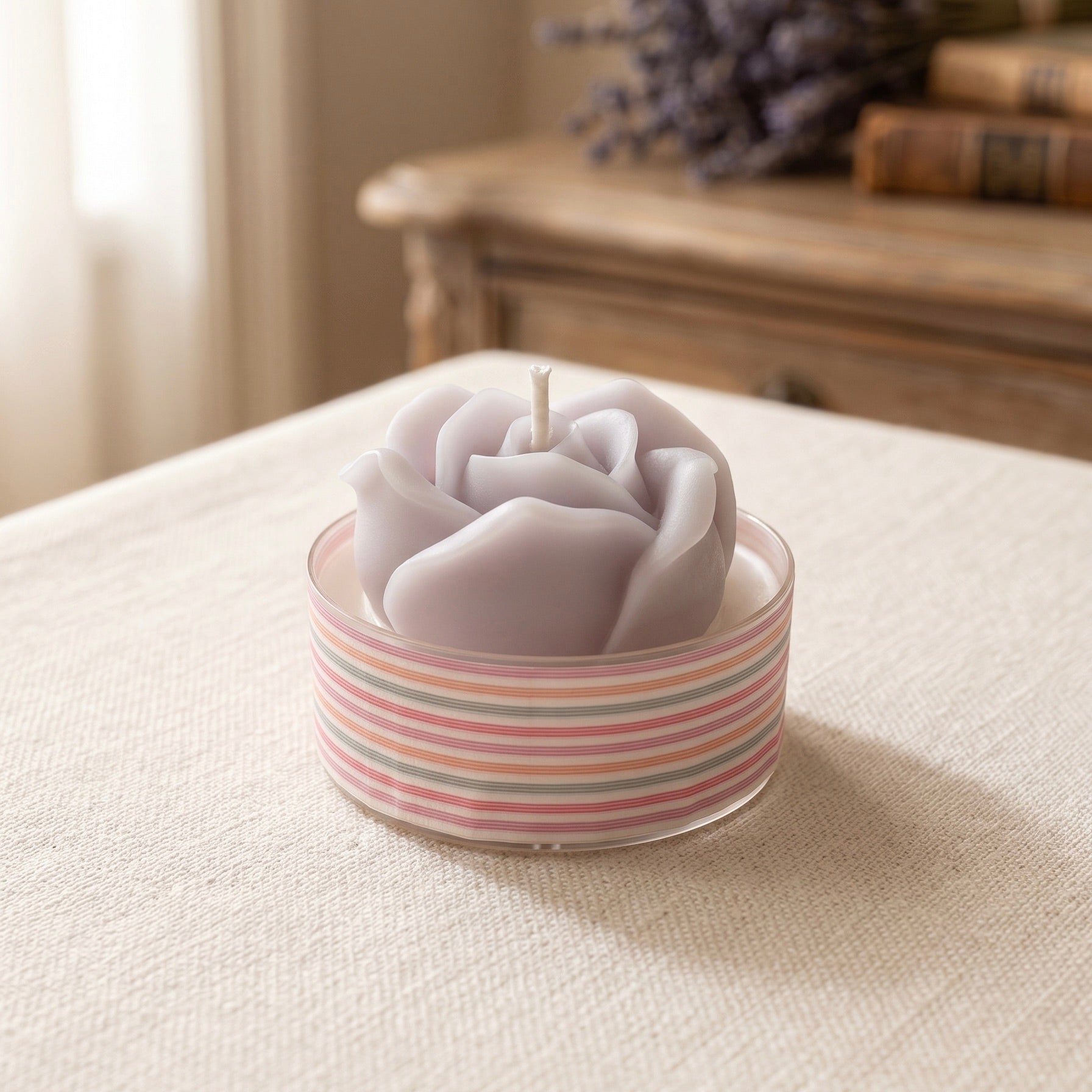 Handmade mini scented candle with a sculpted rose detail in a striped glass vessel from the Everyday Glow collection